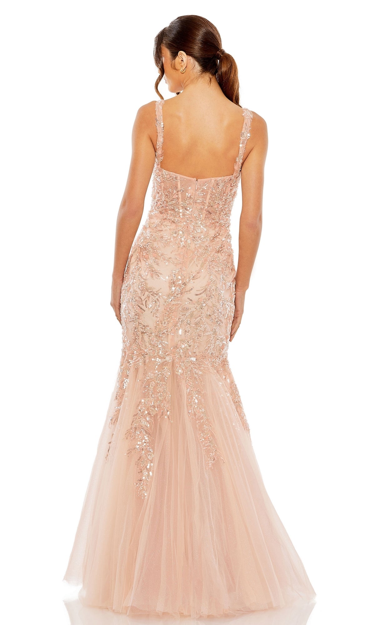 A woman faces away wearing the Long Formal Dress 20559 by Mac Duggal, a floor-length light pink mermaid gown with floral sequin embellishments and a tulle skirt.